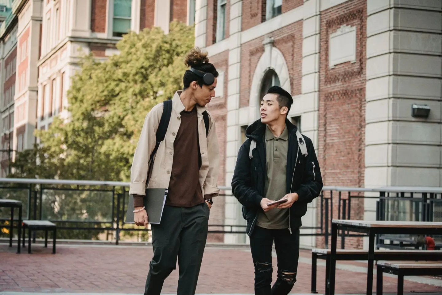 Two university students walking and talking outside a campus building