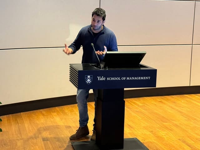 Hassan Akram at the Yale School of Management lectern