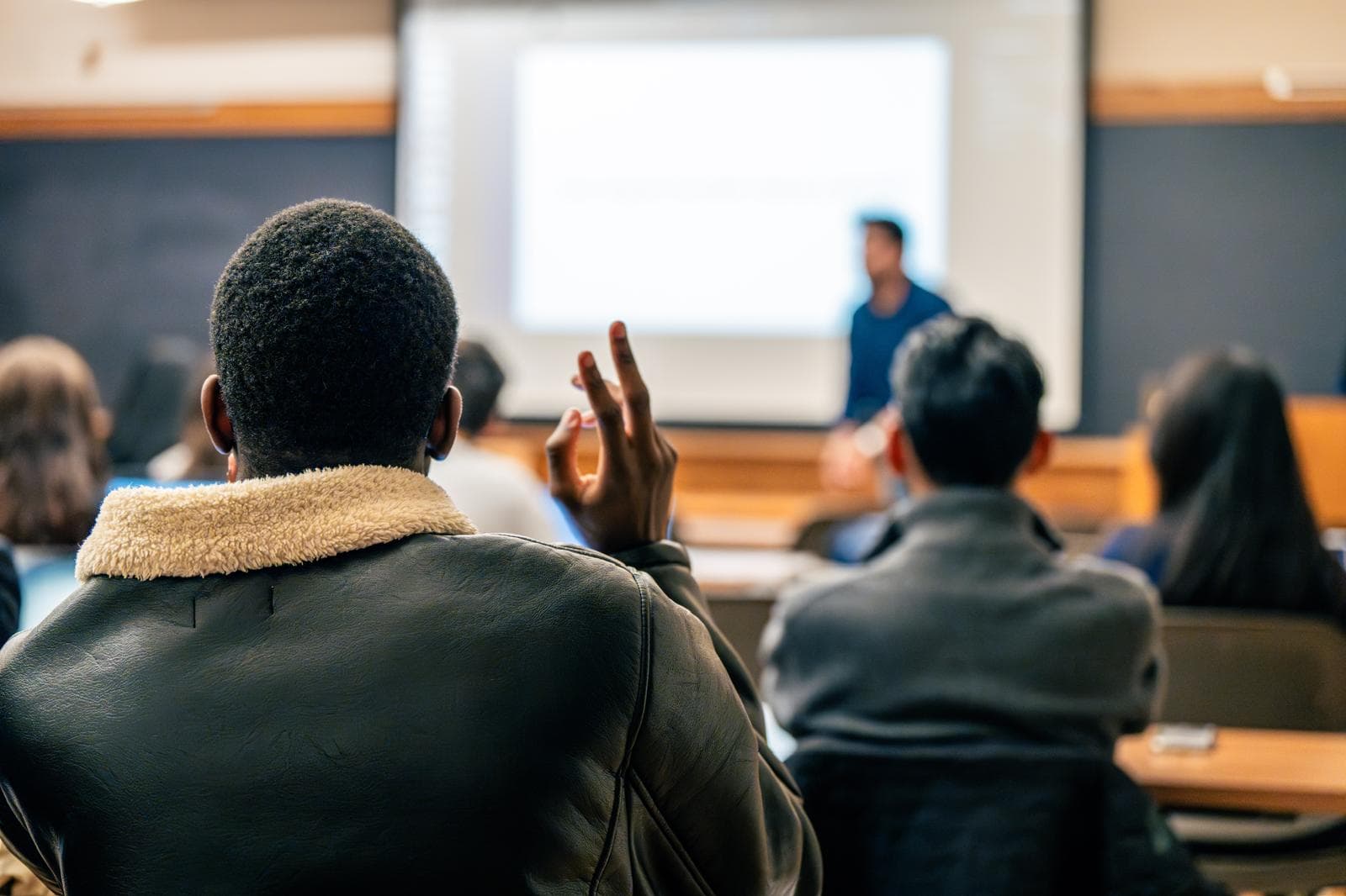 A student raising his hand during Hassan Akram's student-club workshop at Yale School of Management.